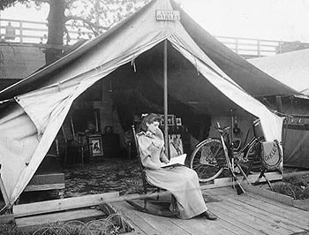 Annie Oakley reading in front of the tent that served as her home
