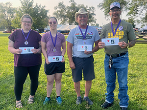 Photo of 4 people wearing medals